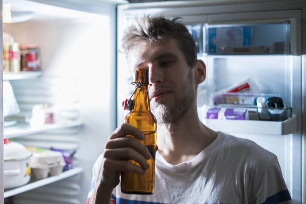 Dude drinking beer from fridge