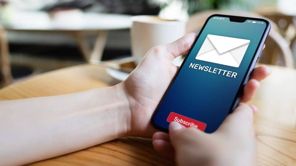 Newsletter subscription button on mobile phone screen. Business marketing concept.