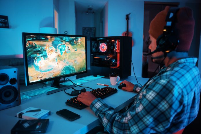 Man playing game on PC with headset