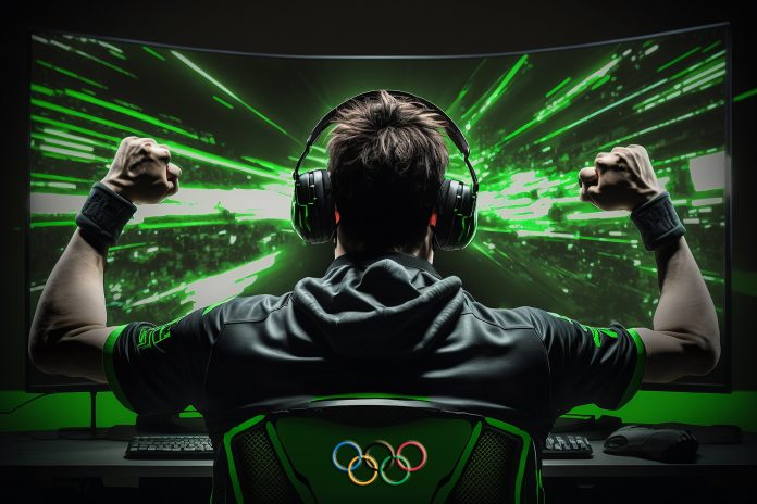 olympic eSports player celebrating in front of large computer monitor with Olympic symbol on chair